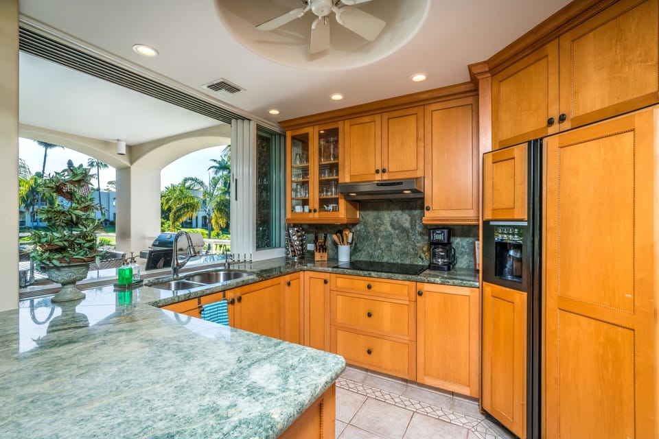 Fully stocked kitchen with large window wall opens easily to the outside.