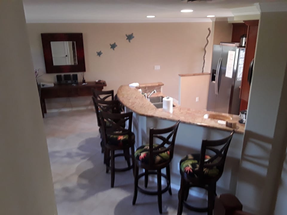 View of the kitchen bar & newly reupholstered bar stools from the staircase.