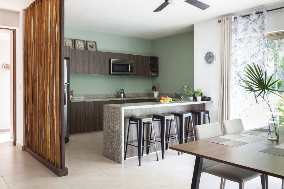 Modern kitchen with stainless steel appliances & dining counter top & bar stools