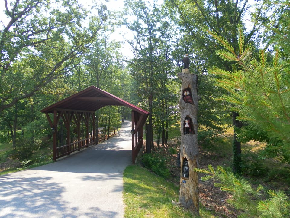 Totem Pole with chainsaw carvings by covered bridge.