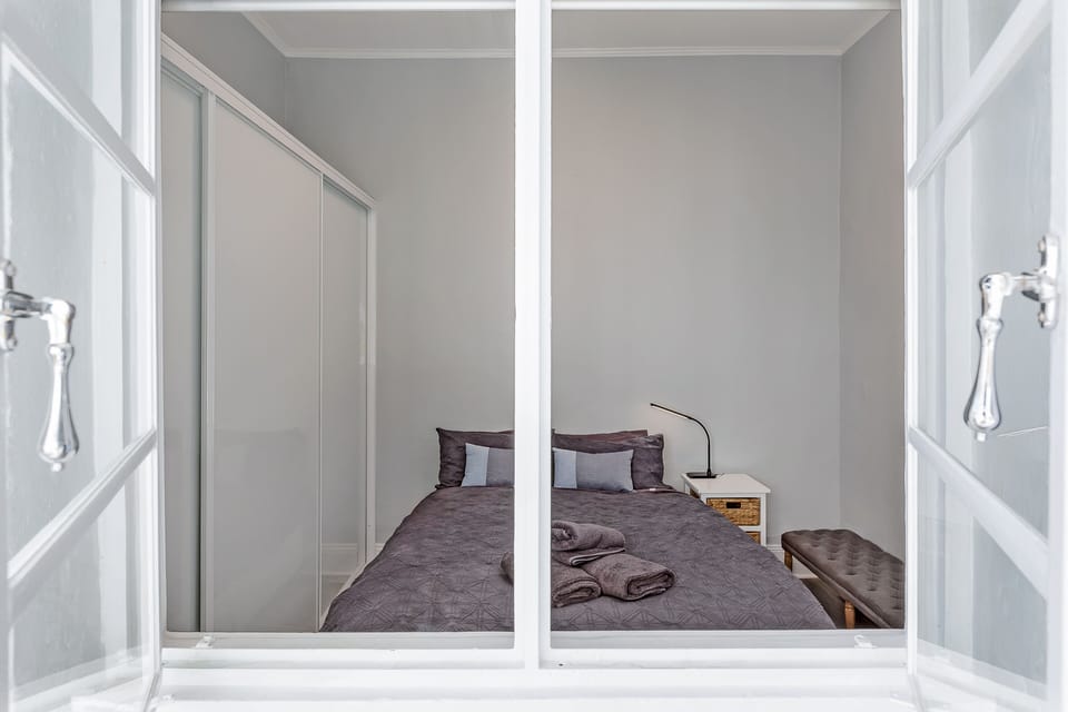 Sleep in a Queen size bedroom with high ceiling and natural light.