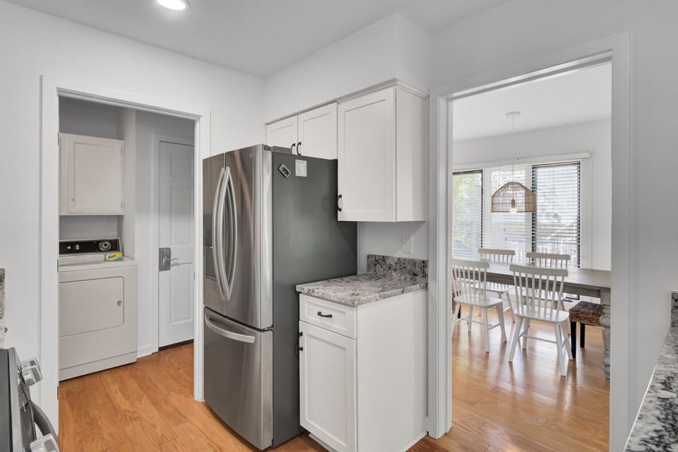 Your sleek white kitchen features stainless steel appliances and granite countertops, perfectly connected to the bright dining area.