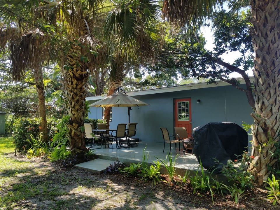 Old Florida tropical landscaping provides private outdoor grilling and dining.