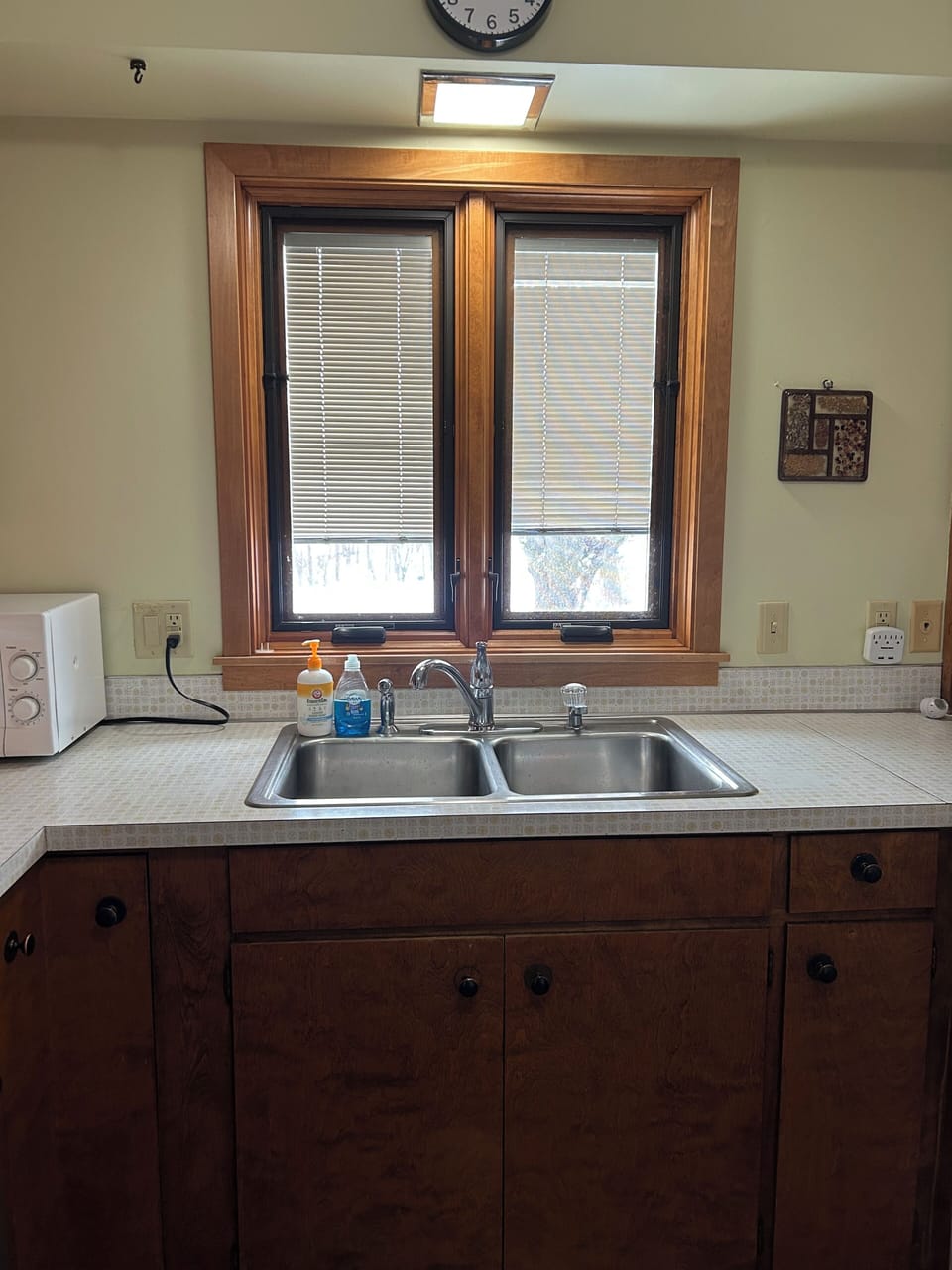 Kitchen sink looks out the front of house.  Garbage disposal.