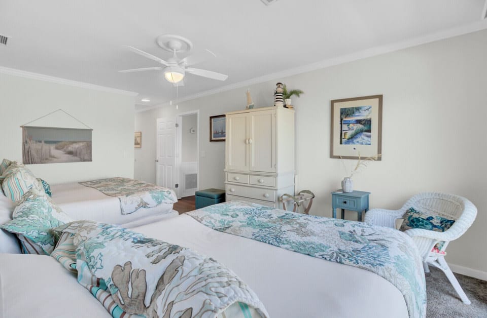 - Two comfortable beds dressed in ocean inspired prints for a fresh coastal vibe - Classic furnishings, soft blue accents, and plenty of natural light fill the space - Thoughtfully styled with art, storage, and a calming palette for a restful stay