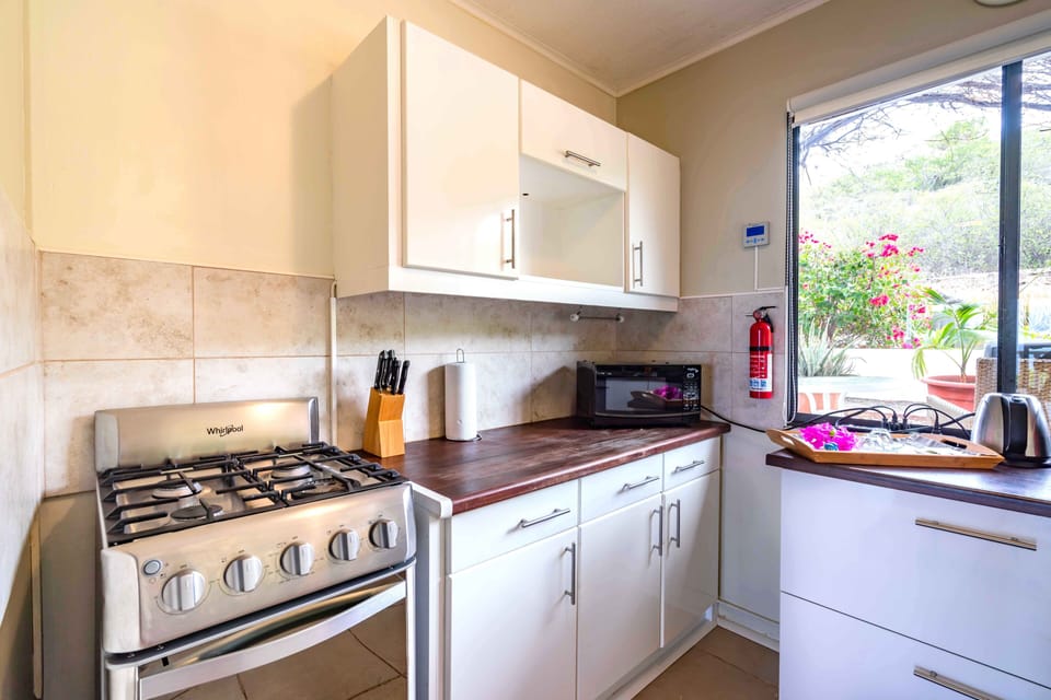 Fully equipped kitchen with gas stove, storage cabinets, fire extinguisher