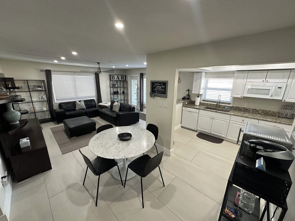 Open living area with kitchen table and counter with barstools 

