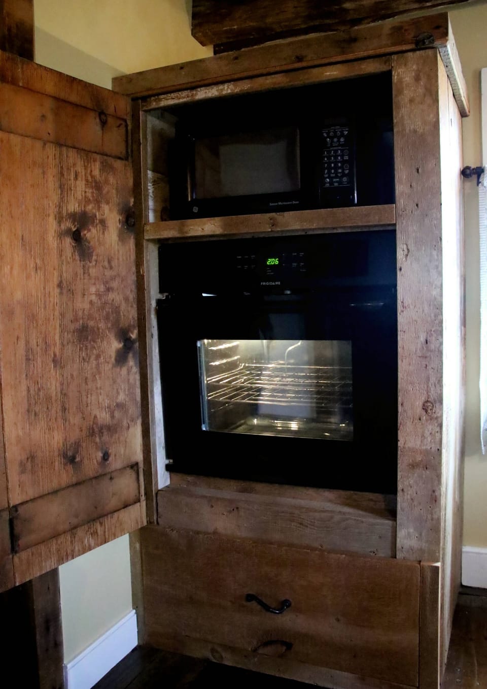 microwave and oven, pull out drawer of pots, pans and baking dishes