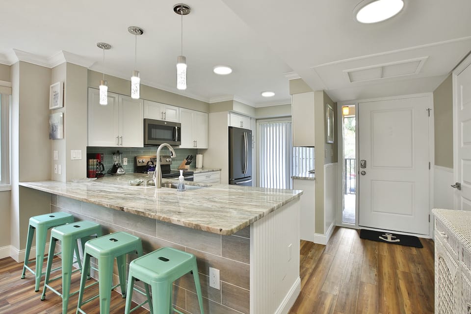 Removed wall to kitchen and added large exotic stone eat at bar area. 