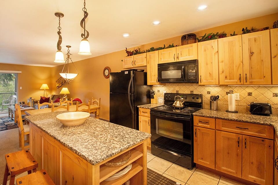 Your fully equipped kitchen invites culinary adventures with granite counters, modern appliances, and warm wood cabinets creating the perfect cooking retreat.