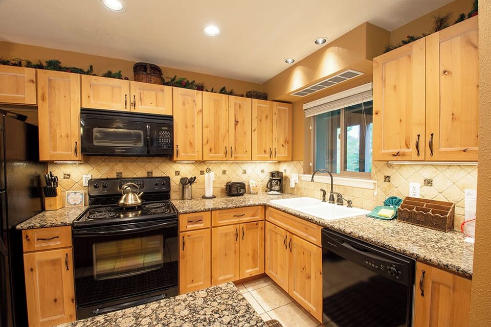Your fully equipped kitchen awaits with granite counters, warm wood cabinets, and everything needed to create memorable meals together.