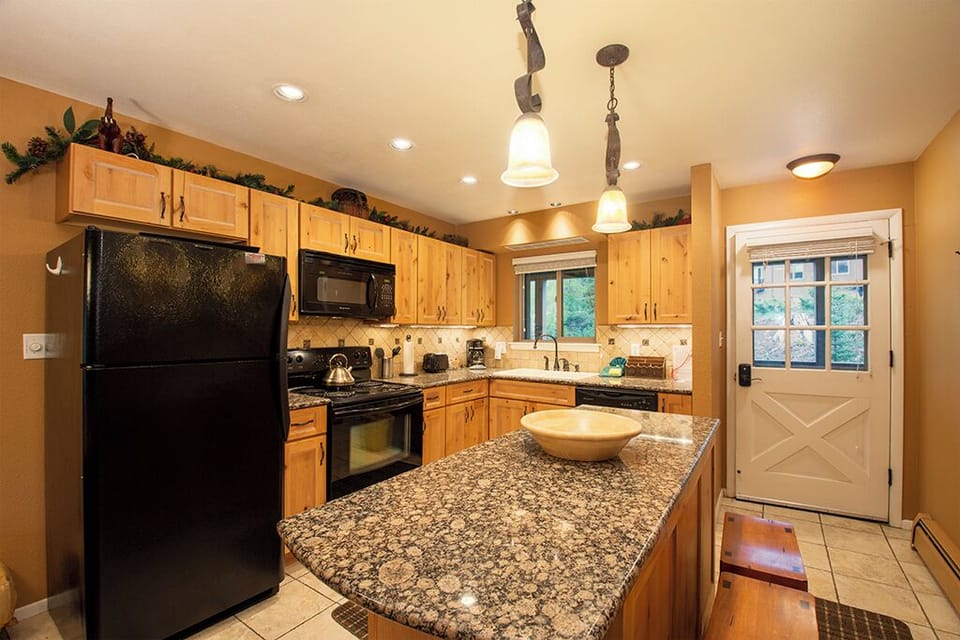 Your fully equipped kitchen features granite countertops and warm wood cabinetry, perfect for preparing meals during your stay.