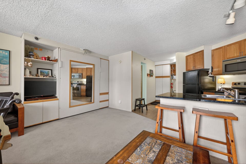 Step into your open-concept retreat where a sleek kitchen, cozy dining bar, and entertainment center create the perfect space for relaxing after a day of mountain adventures.