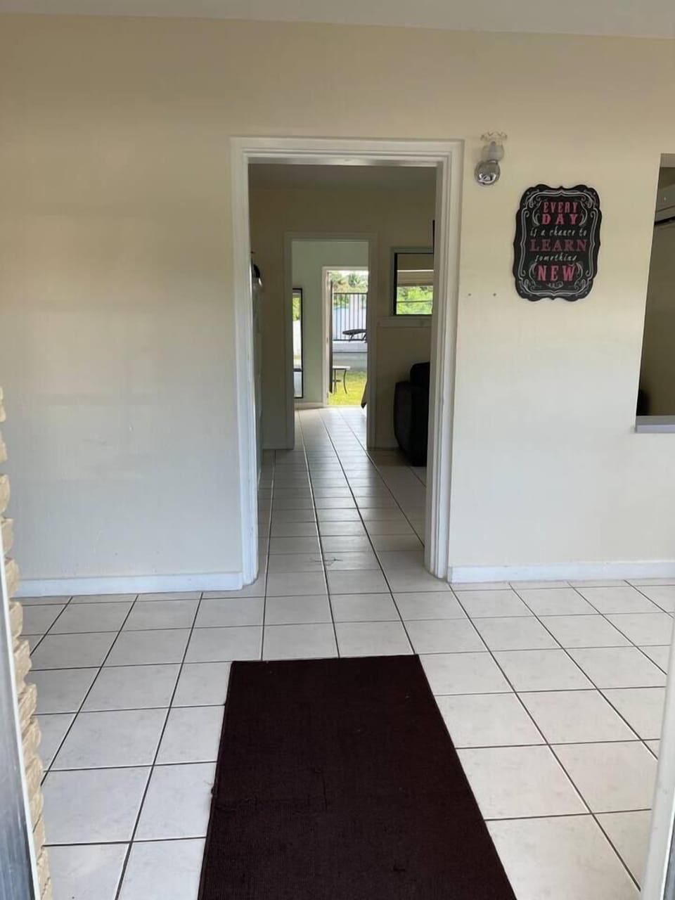 Standing in the front door, looking through the front room, the living/kitchen, the bedroom, and out to the back yard.