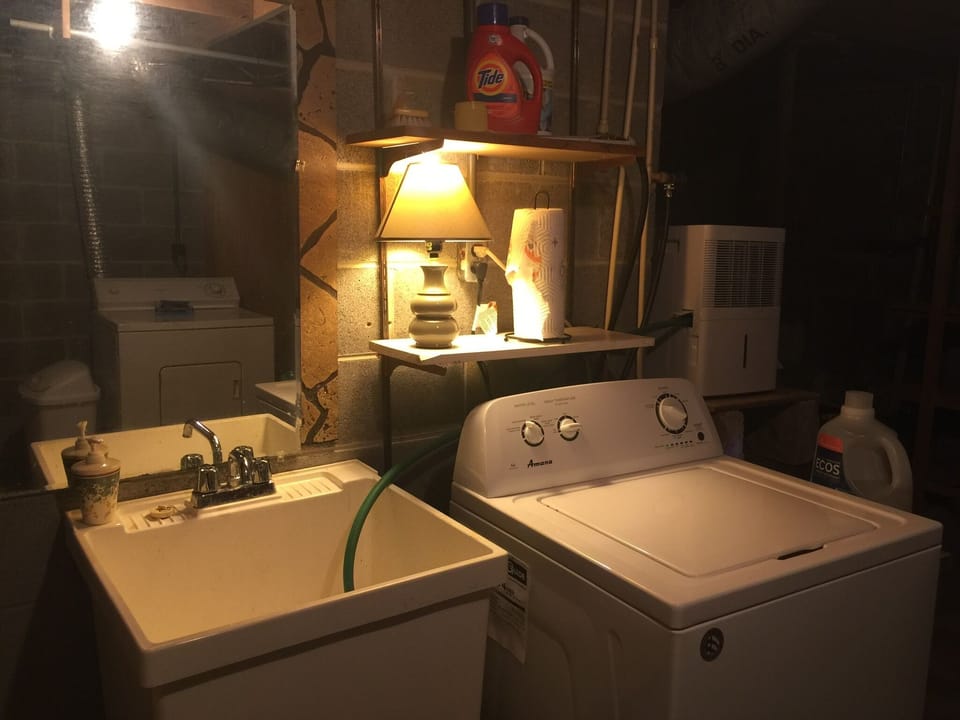 Sink area in basement with mirror. 