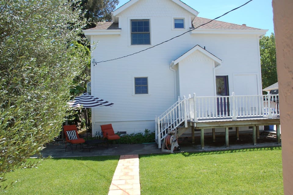 Back of house with private lounge area grassy leading to the relaxing hot tub.