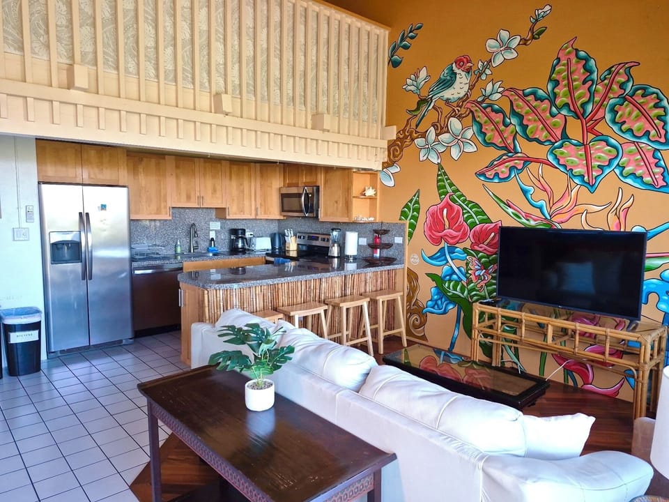 Living room with mural, TV &leather couch that turns into a queen bed .