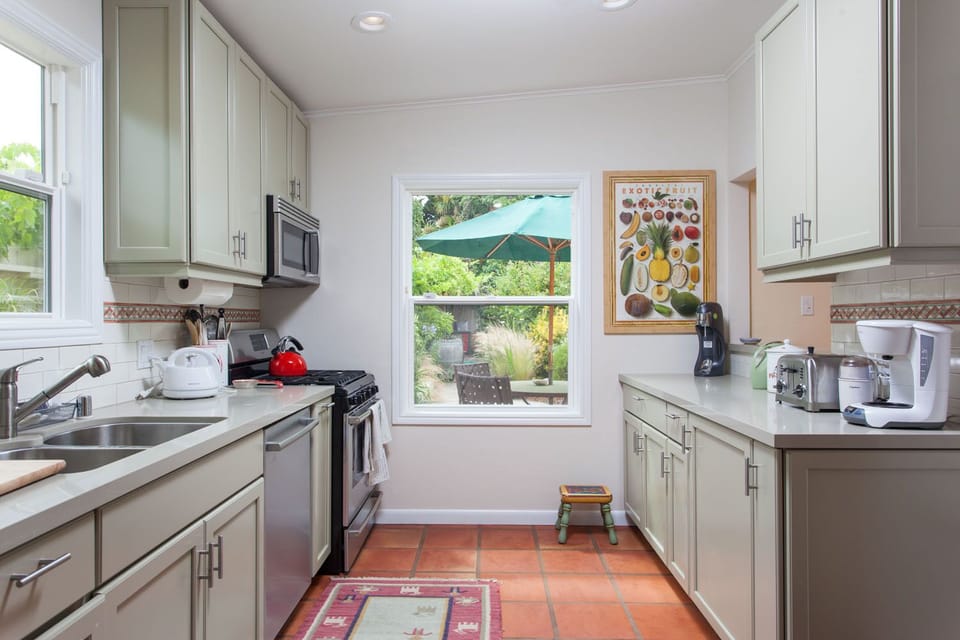 A bright kitchen with a lot of cabinets and kitchen tools
