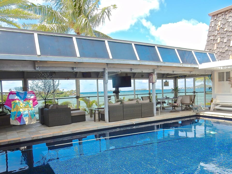 Bayview deck on main level w/ lounge and dining area adjacent to salt water pool