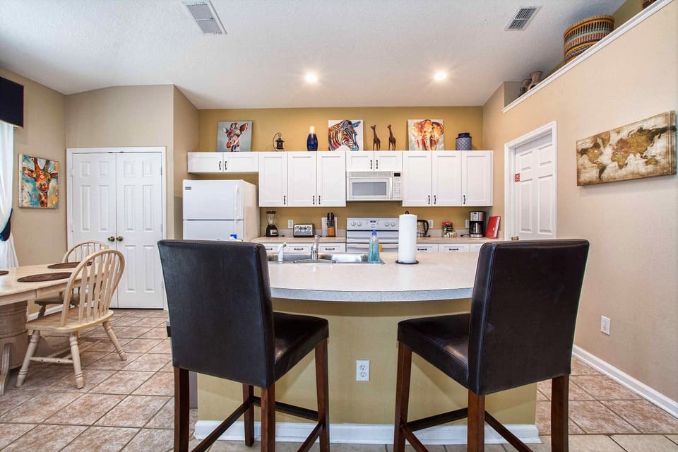 The kitchen with a couple counter seats.