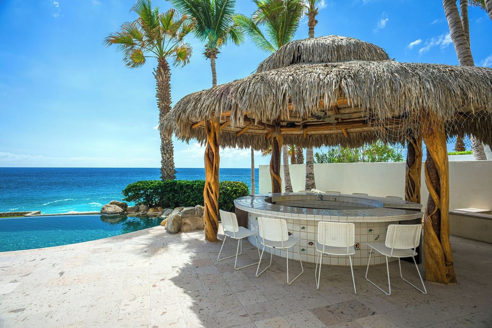 Thatched palapa bar with ocean and pool views at Casa Edwards Too, Punta Bella, Los Cabos.