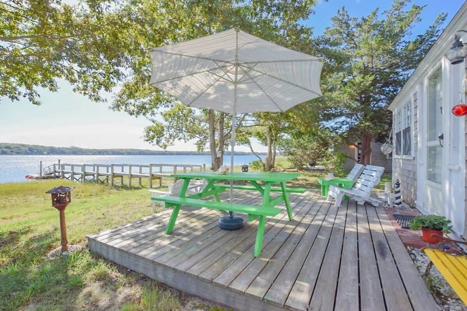 Porch at back of home with picnic table, overlooking cove