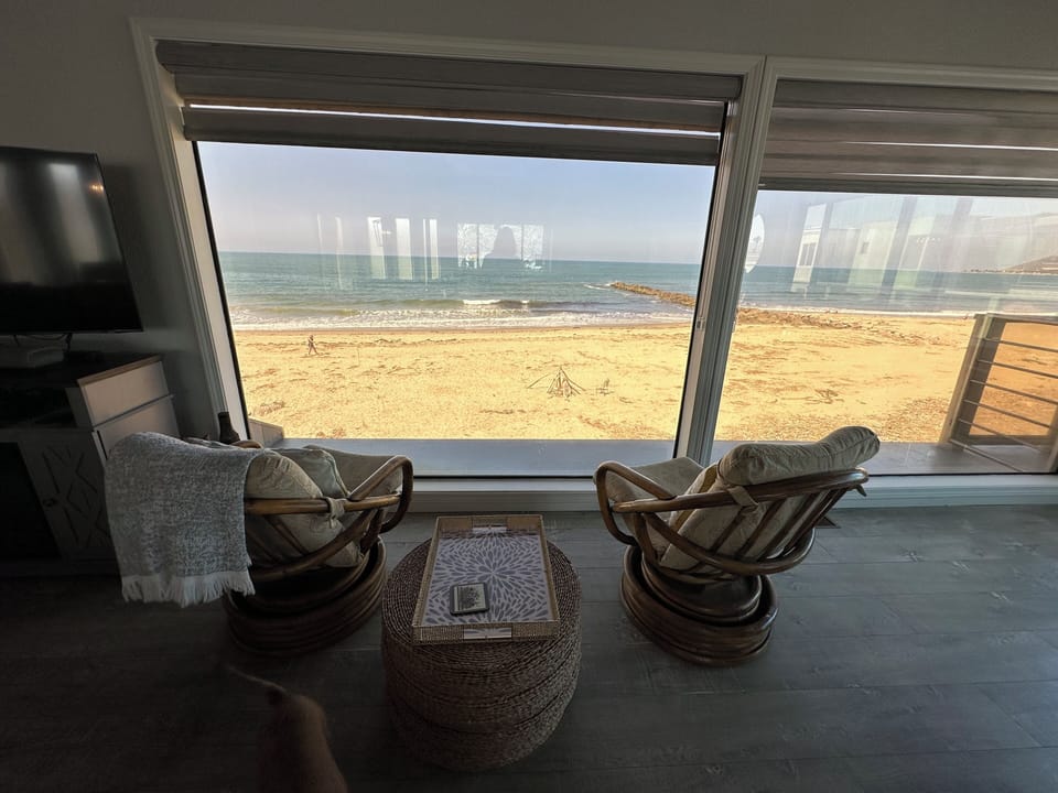 Great views upper living area looking thru floor to ceiling windows at beach