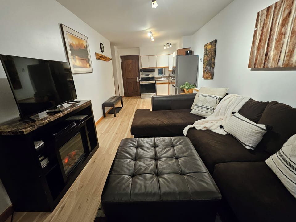 Living room with cozy warm fireplace and comfy sofa that seats 5