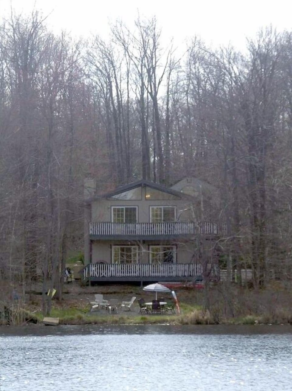 View of lake house and backyard from across the lake