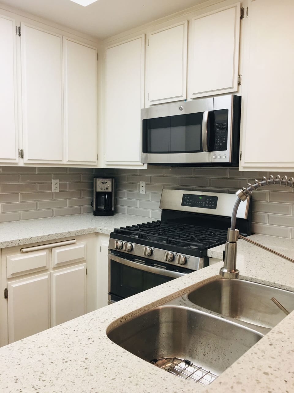 Oven & microwave w/ new quartz countertop, stainless steel sink & faucet. 