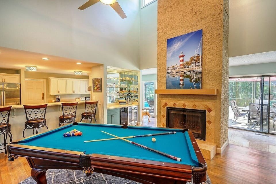 The Den with pool table and wet bar that has an ice maker and wine fridge below.