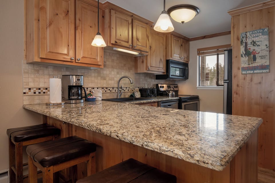Your fully equipped kitchen features granite counters, warm wood cabinets, and modern appliances for effortless meal prep.