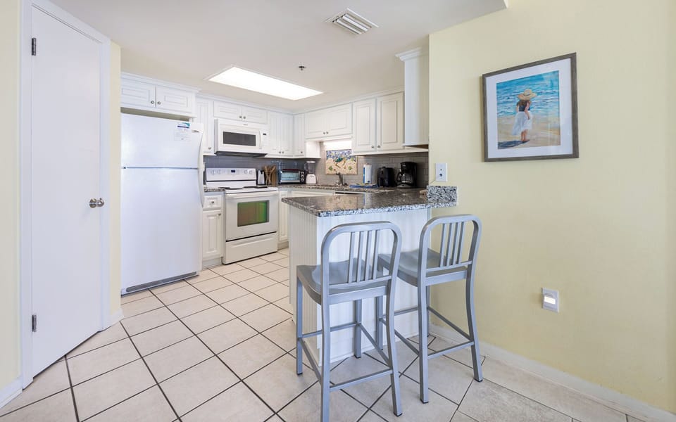 A cozy kitchen with granite breakfast bar lets you sip morning drinks and plan your day ahead