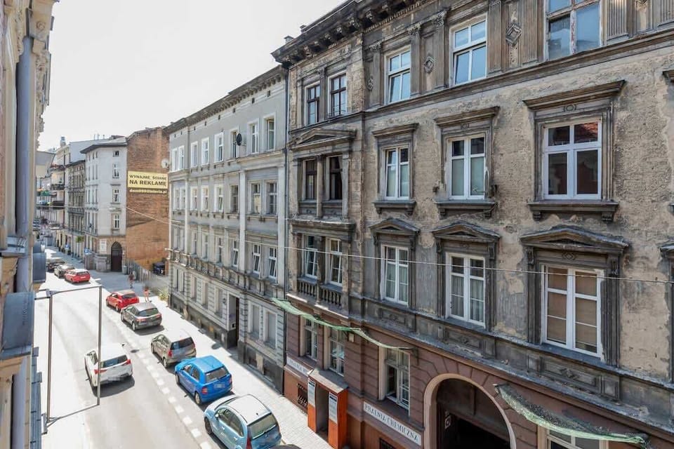  A picturesque street view of a narrow European road lined with traditional buildings. The street is filled with parked cars, and the classic architecture gives it a historic charm.