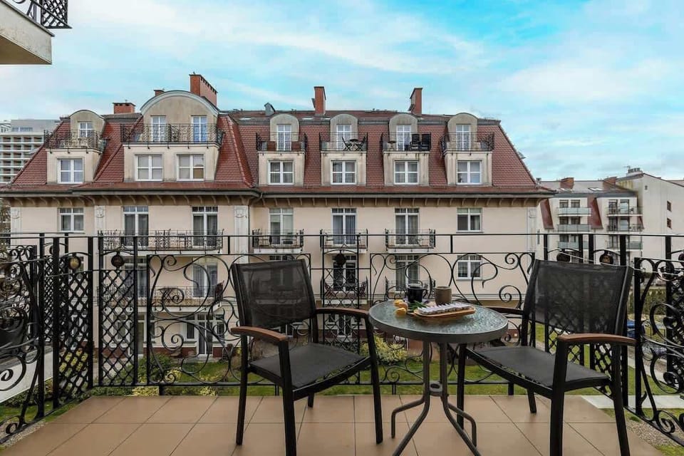 Balcony with chairs and table overlooking the surrounding area.