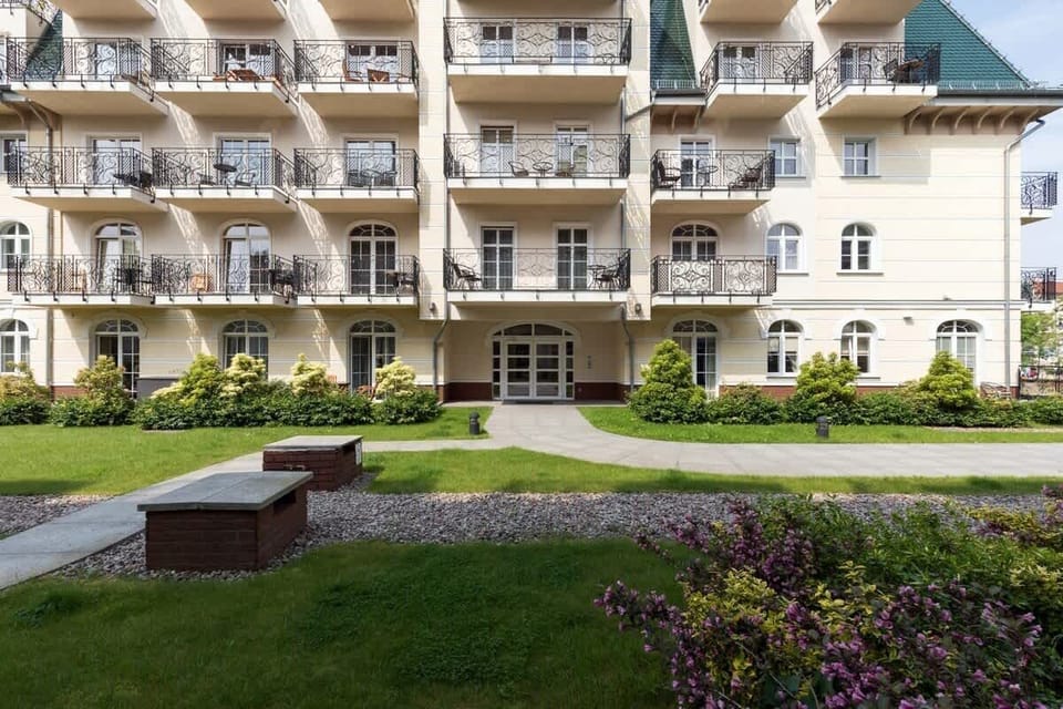 A building with balconies in which the flat is located. The neighbourhood is nice and green.