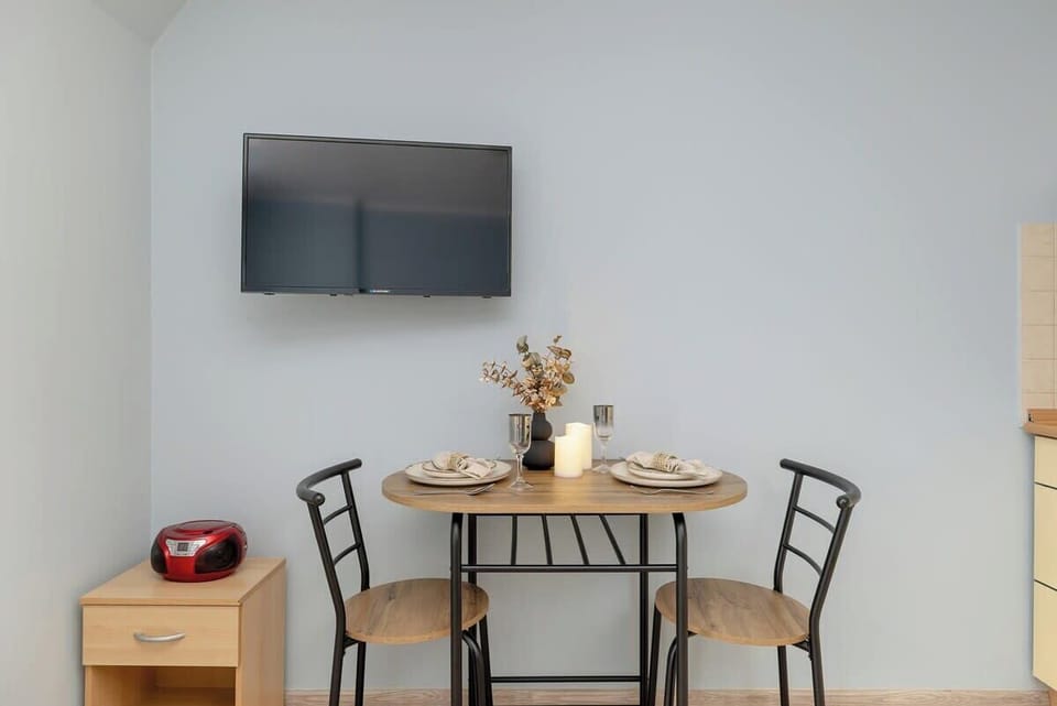 A stylish decor arrangement on the dining table, featuring candles and a vase. This touch creates a welcoming dining setup.
