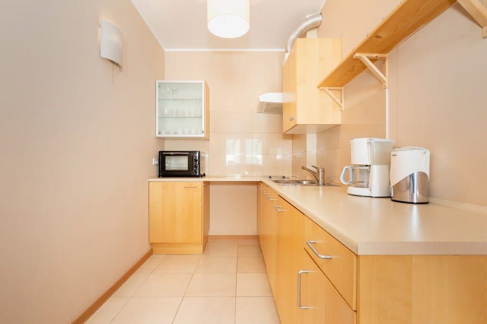 A spacious kitchen with light-colored cabinets, an electric kettle, and plenty of countertop space, ideal for cooking and meal preparation.