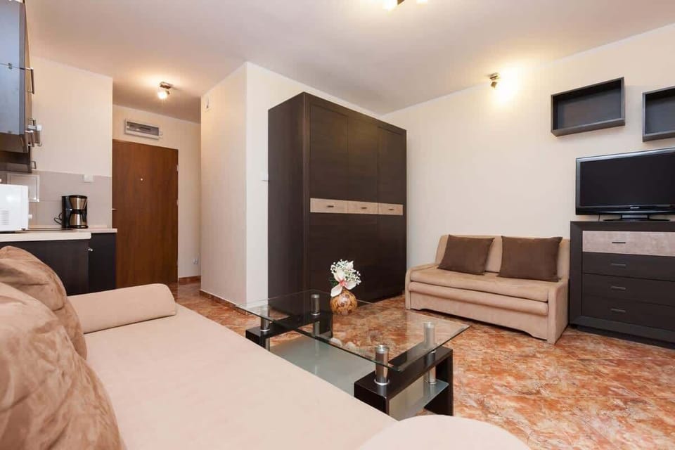The living room with the couch, coffee table, and TV visible again. This angle also highlights the open space leading toward the kitchen.