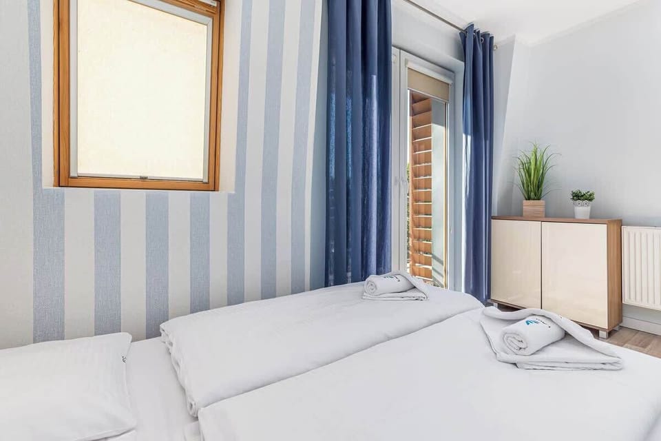 Elegant and atmospheric bedroom with dark blue curtains, double bed and cabinet.