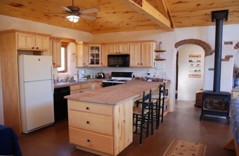 Spacious and fully equipped kitchen with extra seating at natural slate counter.