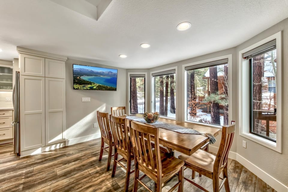 Gather around your warm wood dining table where forest views frame every meal through expansive windows.