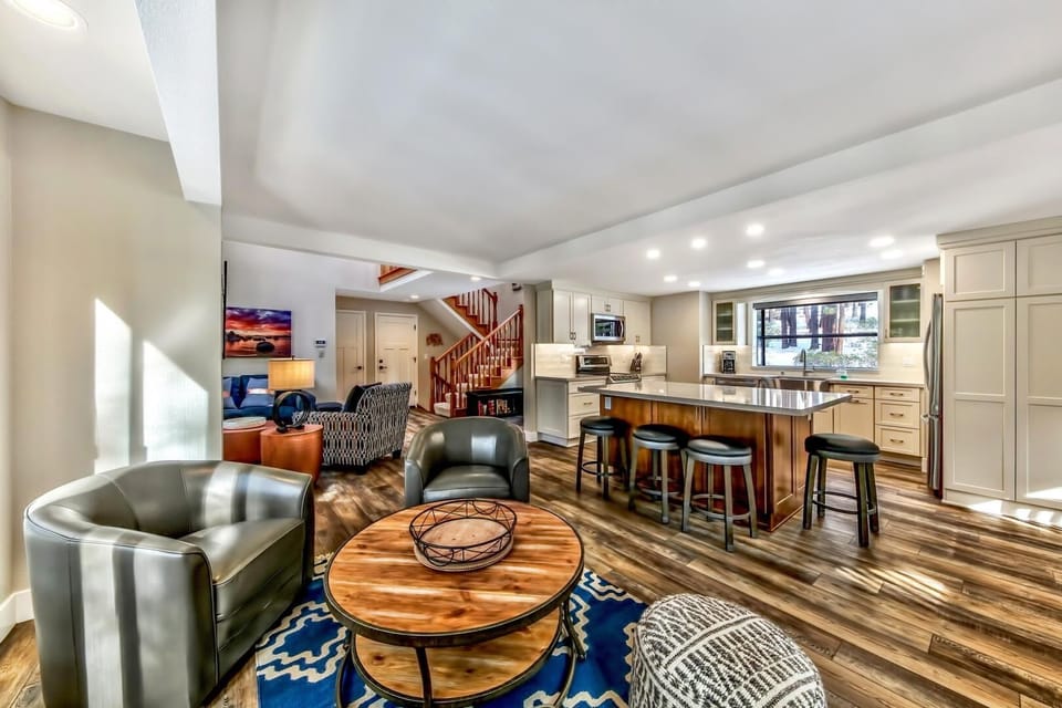 Sink into leather chairs beside your kitchen island where morning coffee flows into evening conversations in this open living space.