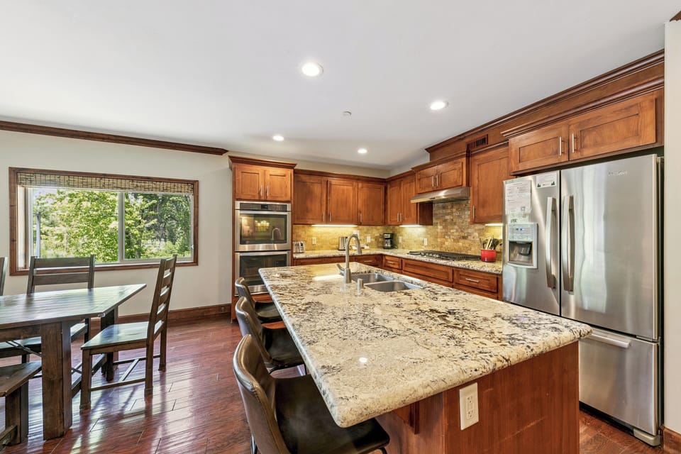Gather around this stunning granite island where morning coffee and evening conversations flow naturally in your gourmet kitchen.