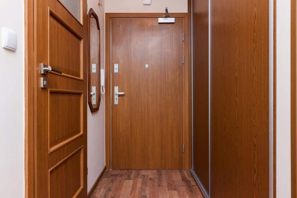 A hallway where a mirror hangs on the wall.