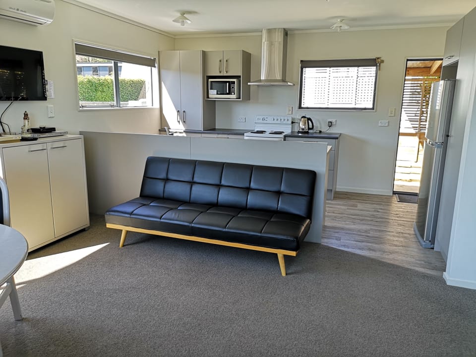 Sofa bed, tv on the wall.  Looking towards the kitchen.