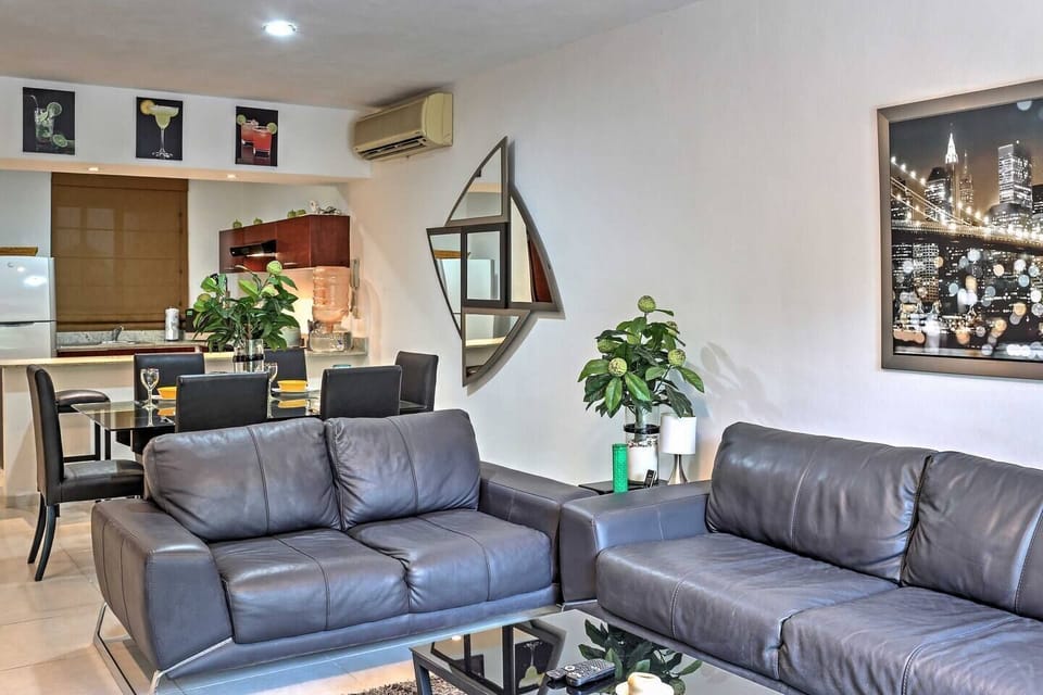 Living room couches & dining table. Kitchen visible in back.