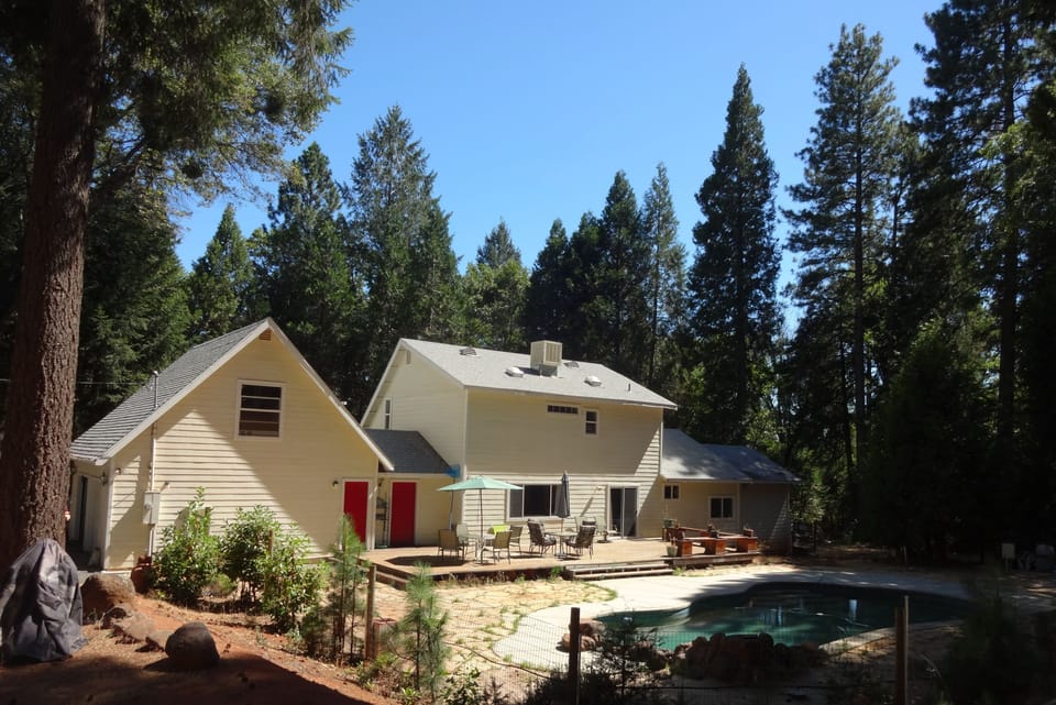 View of back of home with deck and pool.