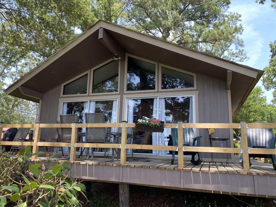 Deck with table and chairs, 2 rockers and 2 lounge chairs, plus charcoal grill.