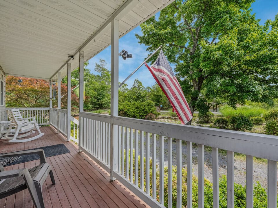 Front porch with rocking chairs, extra seating and a cover to keep rain away